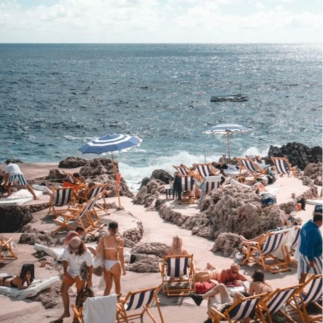 Beach goers enjoying the rocky beach along Capri in Italy.