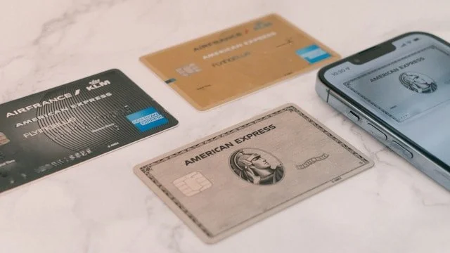 A trio of American Express credit cards sit on a table.
